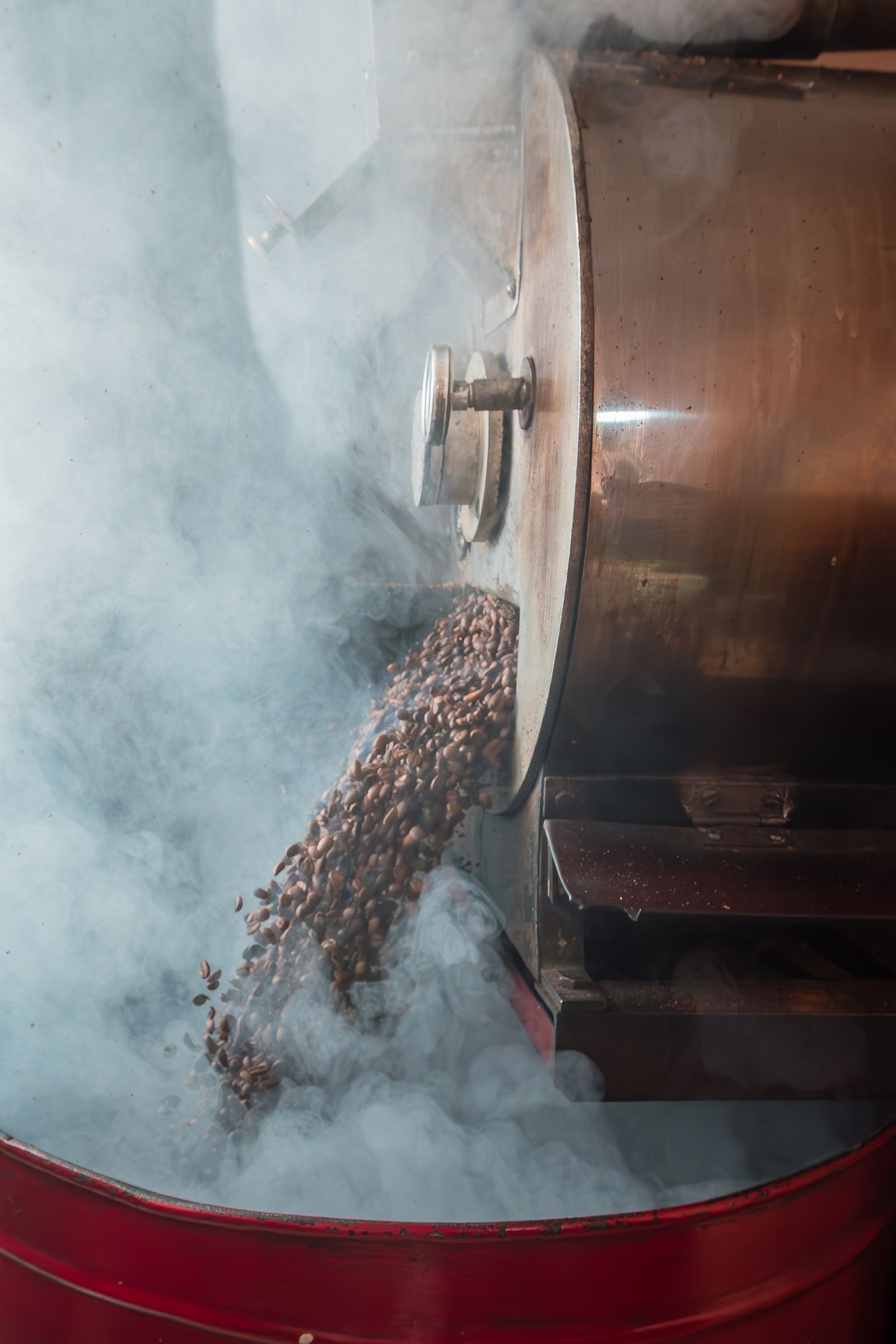 Steam rising from a drum roaster in low light